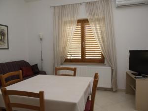 - un salon avec une table blanche et une fenêtre dans l'établissement Apartments Sara, à Pula