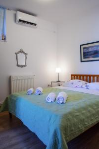 ナフプリオにあるMatina's house vacation rental in Nafplioのベッドルーム1室(ベッド2台、緑のベッドカバーにタオル付)