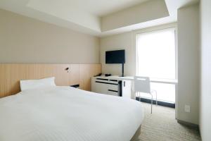 A bed or beds in a room at JR Inn Sapporo-eki Minami-guchi