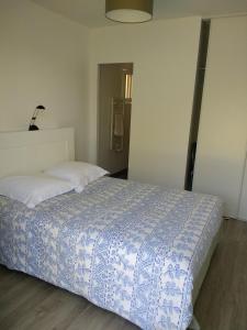 a bedroom with a bed with a blue and white comforter at villa terrefort in Drémil-Lafage +21 photos
