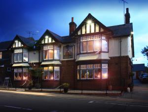 a large red brick house with lights in the windows at The Oyster Smack in Burnham on Crouch