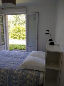 1 dormitorio con cama y ventana en villa terrefort, en Drémil-Lafage