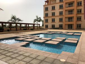 a swimming pool in front of a building at Studio Marina 2 in King Abdullah Economic City