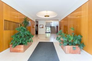 un couloir avec deux plantes en pot dans un immeuble dans l'établissement Appart Terrasse Vue Tour Eiffel, à Paris