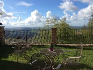 a patio with tables and chairs and a fence at B&B San Nicolò in Montegiorgio