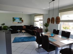 a living room with a table and a couch at Modernes Ferienhaus der besonderen Art mit Garten in Löhne