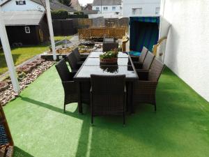 a table and chairs on a patio with green grass at Modernes Ferienhaus der besonderen Art mit Garten in Löhne