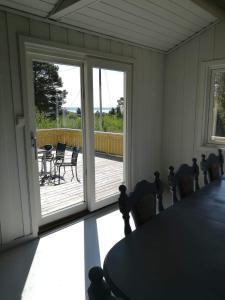 a room with a table and chairs and a sliding glass door at Teibernveien 86, Larkollen (Rygge, Norways) in Rygge