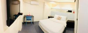 a bedroom with a bed and a table with a camera at Hometown Hotel - Lacson Bacolod in Bacolod