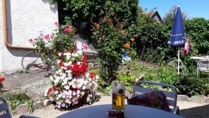 ノイキルヒェン・バイム・ハイリゲン・ブルートにあるDankaの花の前にワインを一杯付けたテーブル
