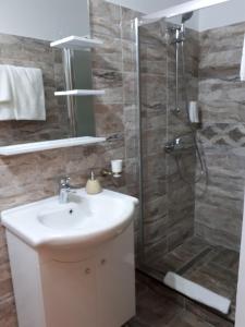 La salle de bains est pourvue d'un lavabo et d'une douche. dans l'établissement Casa Pozitiv Relax, à Buzău