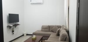 a living room with a couch and a tv at Alhama Hotel Appartment in Khasab