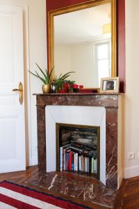 a fireplace in a living room with a mirror at Anna's Home Sweet Home in Boulogne-Billancourt