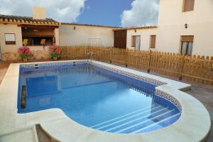 a swimming pool in a yard next to a house at Casa Rural la Quinteria de Sancho piscina para tres apartamentos in Argamasilla de Alba