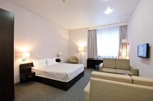 ペルミにあるHotel City Starのベッドとソファ付きのホテルルーム