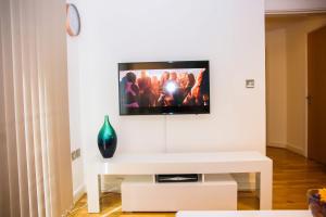 ein Wohnzimmer mit einem TV an einer weißen Wand in der Unterkunft Superior 2 bedroom Apartments in Woolwich