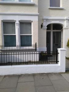 a black fence in front of a house at 64 Wardo Avenue in London