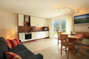 uma cozinha e sala de estar com um sofá e uma mesa em Haus Monika em Brixen im Thale