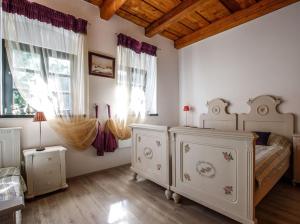 a bedroom with a bed and two dressers and windows at Cselling Udvarház in Révfülöp