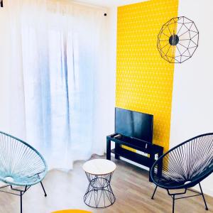 salon z 2 krzesłami i telewizorem w obiekcie BtoBed - Paris Nord Villepinte w Villepinte