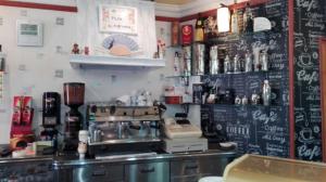 a coffee shop with a bar with a chalkboard wall at Hostal Almenara in Paterna del Madera