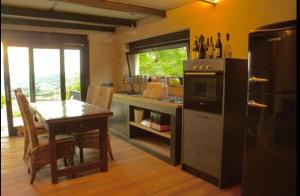 eine Küche mit einem Tisch, einem Herd und einem Kühlschrank in der Unterkunft Cascina Linét in Novello