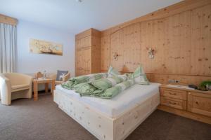 a bedroom with a large bed with a wooden wall at Hotel Felsenstüberl in Sölden