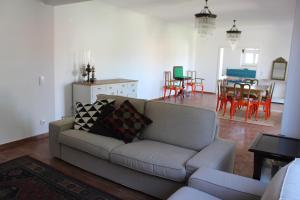 a living room with a couch and a dining room at HappySintra GuestHouse by Casa do Preto in Sintra