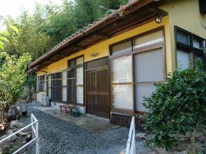 una casa gialla con un mucchio di finestre di 民宿たきた館 guest house TAKITA-KAN a Iwaki