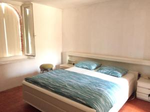 1 dormitorio con 1 cama con 2 almohadas azules en Maison du Fermier, en Épineuil-le-Fleuriel