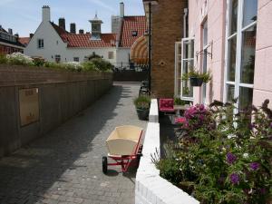 a red and white cart sitting on a brick walkway at Dar Cho Apartment in Zandvoort