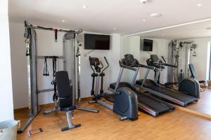 a gym with several tread machines in a room at Hotel Boutique & Spa Las Mimosas Ibiza in San Antonio Bay