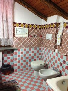 een betegelde badkamer met een toilet en een wastafel bij Penisola Verde b&b in Locri