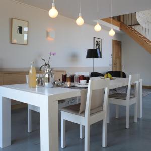 een witte eettafel en stoelen in een kamer bij B&B Het Rooj in Holsbeek