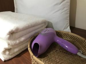 納泰海灘的住宿－蘭塔拉旅館，床上一篮子中的紫色吹风机