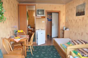 a small room with a bed and a table and a kitchen at Budziar - kwatery nad morzem in Darłowo