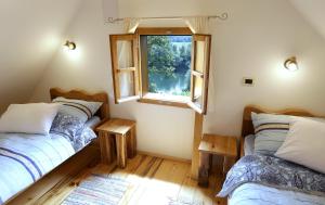 two beds in a room with a window at Kuca Suncani brijeg in Pokupsko