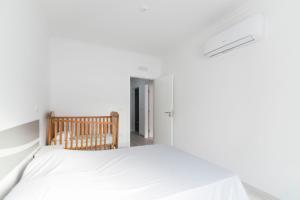 - une chambre blanche avec un lit et une chaise dans l'établissement Villa UA, à Pias