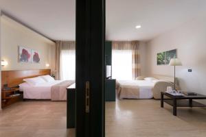 Rúm í herbergi á Astoria Suite Hotel