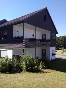 Casa grande en blanco y negro con balcón en Pension Orketal, en Medebach