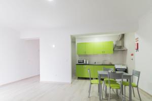 Una cocina con gabinetes verdes y una mesa y sillas. en Villa UA, en Pias