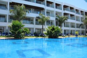 a large swimming pool in front of a hotel at Zaki Suites Hotel & Spa in Meknès