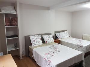 two beds in a room with white sheets and flowers at Hameau des Essarts in Grand-Couronne