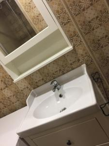 un lavandino bianco in un bagno con specchio di Apartamento Tolaitola a Toledo