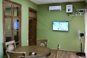 uma sala de jantar com uma mesa e uma televisão na parede em Dilijan Town Inn em Dilijan