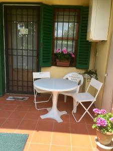 a table and chairs on a patio with green shutters at La Casina di Eleonora in Mosciano