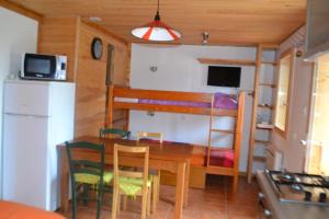 uma sala de jantar e cozinha com uma mesa e um beliche em Petit appartement en montagne em Saint-Julien-en-Champsaur