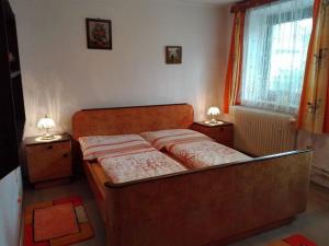 1 cama en un dormitorio con 2 lámparas en las mesas en Pension u Adršpachu - Dana Tyšerová, en Janovice