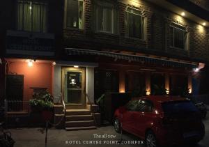 a red car parked in front of a building at night at Hotel Centre Point in Jodhpur