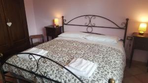 a bedroom with a bed with a black and white comforter at AGRITURISMO Casa Riz in Cormòns